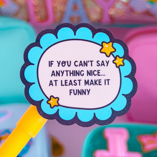 A close-up of a round scalloped sticker or label on a yellow stick, reading 'IF YOU CAN'T SAY ANYTHING NICE.